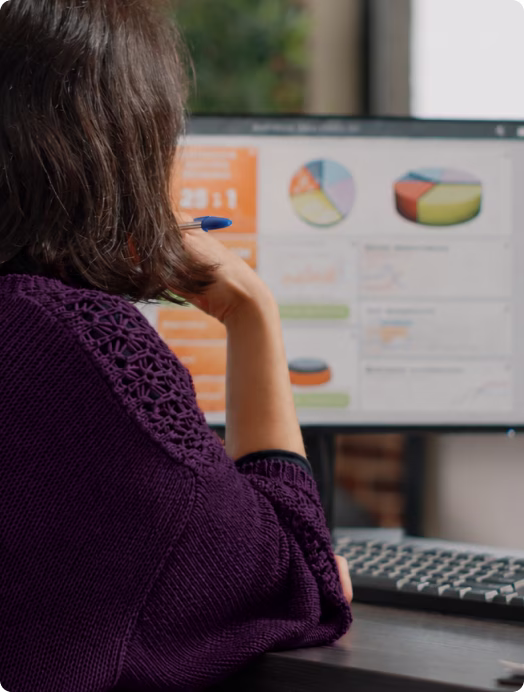 Mulher de costas olhando um monitor com gráficos